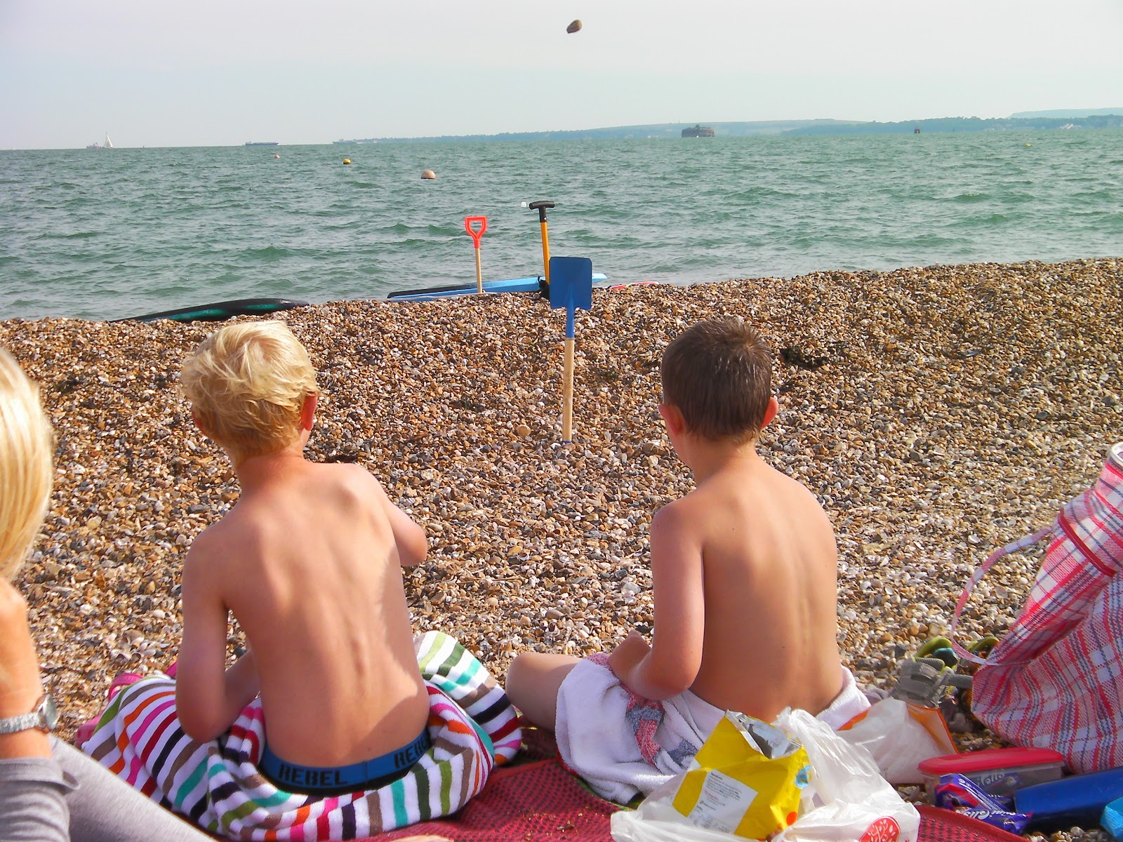 boys throwing stones at a spade as target shingle beach southsea small pebbles ideal for throwing