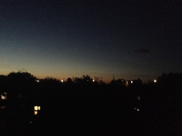 Landscape shot of a night sky horizon, almost at twilight with far off home lights.