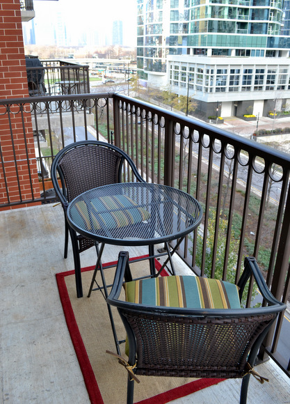 Balcony with two small chairs and a table. 