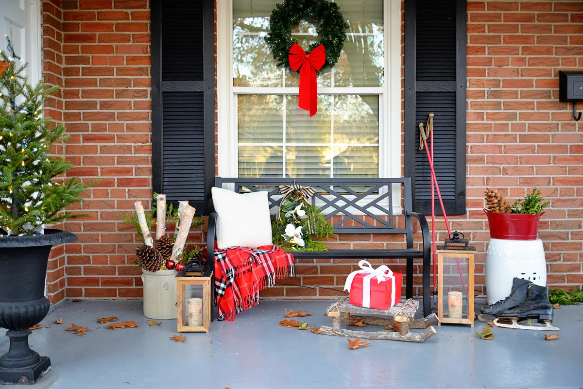 christmas porch decor, porch bench with christmas decorations, ski poles as decor, birch branches in crock