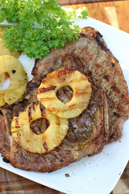 Grilled pork chops with pineapple on white platter