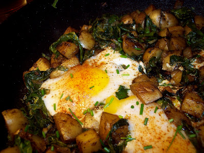 Eggs cooked on top of potatoes and Swiss chard.