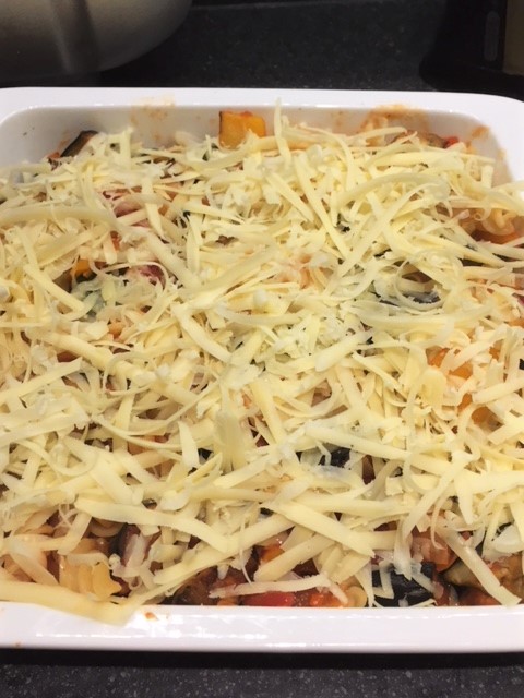 Mediterranean vegetable pasta bake covered in grated cheese