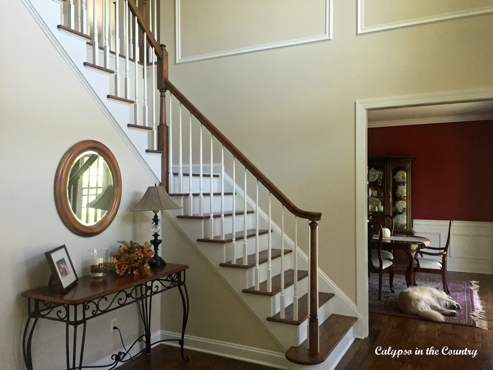 Foyer with traditional staircase and Benjamin Moore White Sand paint on walls