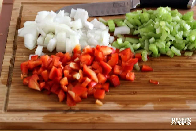 chopped vegetables on wooden board with knife