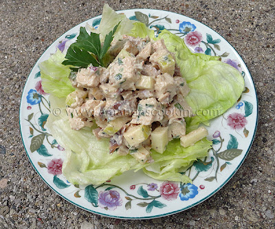 A photo of chicken salad on a piece of lettuce.