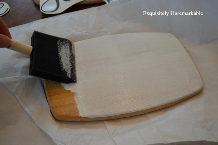 Painting a wooden cutting board white with a foam brush