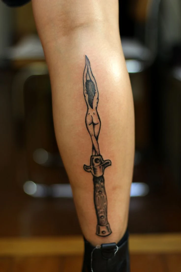 vemos a una mujer joven con tatuaje de cuchillo o tatuaje de daga