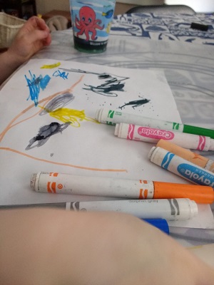 Preschool child painting with markers