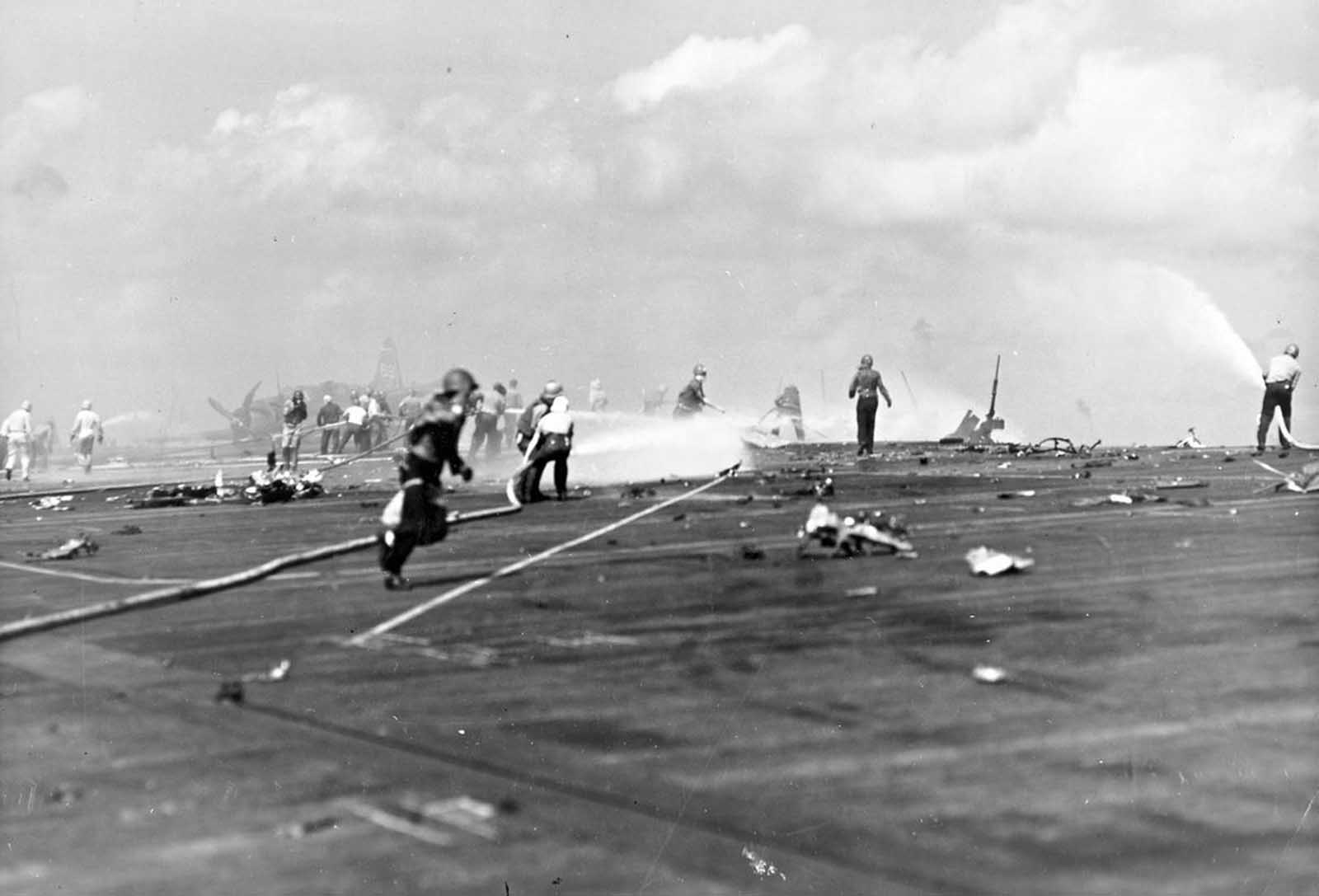 Aftermath of the November 25, 1943 kamikaze attack against the USS Essex. Fire-fighters and scattered fragments of the Japanese aircraft cover the flight deck. The plane struck the port edge of the flight deck, landing among planes fueled for takeoff, causing extensive damage, killing 15, and wounding 44.