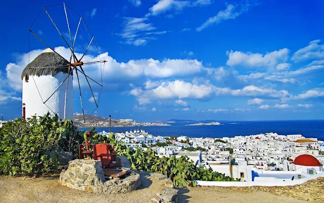 Molen ergens in Griekenland met een stad en de zee op de achtergrond
