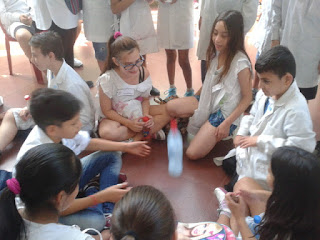 alumnos de diferentes escuelas sentados en circulo tomando el yoghurt
