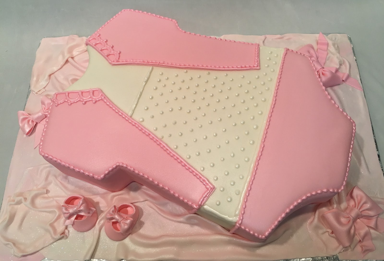 MyMoniCakes Pink baby onesie cake with matching cupcakes