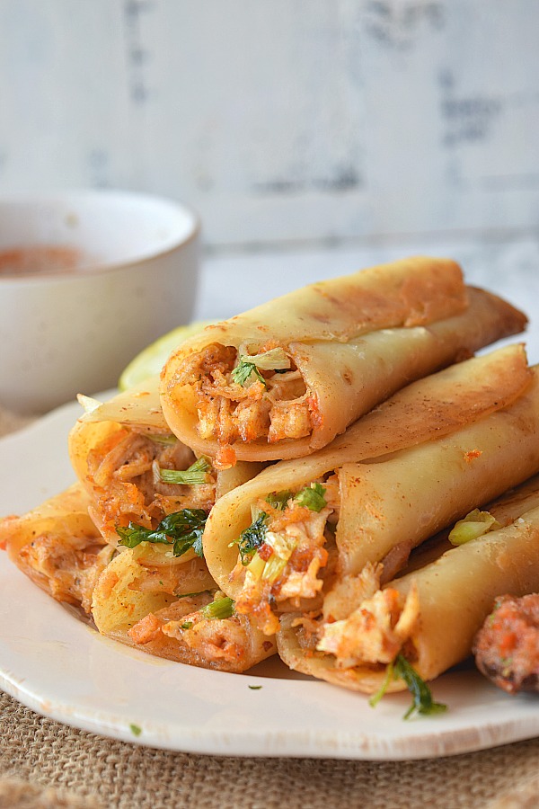 a white plate with chicken cream cheese taquitos