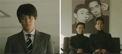 Ishikawa stares at Hacker Simon played by Hamano Kenta 浜野謙太(はまの けんた) and Hacker Garfunkel played by Nomaguchi Toru 野間口徹 (のまぐちとおる)  as they sit in front of a huge photo of themselves.