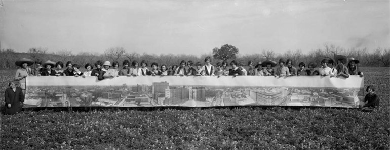 Photo panoramique d'E. O. Goldbeck montant des jeunes filles tenant une photo panoramique de la ville de San Antonio au Texas