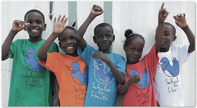 Haitianische Schulkinder mit bunten T-Shirts des Projekts