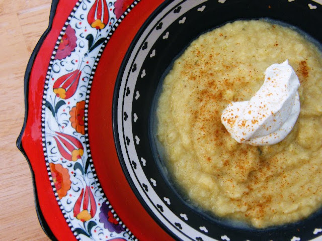 Fresh Ginger & Parsnip Soup in a black bowl topped with a dollop of Greek yoghurt