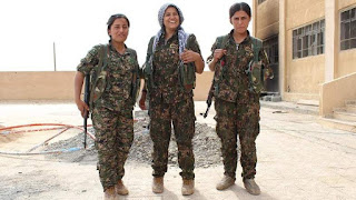 female kurdish fighter dressed in military uniform holding weapons, fighting ISIS