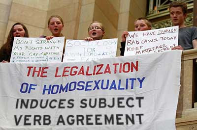 Neatly handmade banner hanging from a Capitol railing revised to read THE LEGALIZATION OF HOMOSEXUALITY INDUCES SUBJECT VERB AGREEMENT