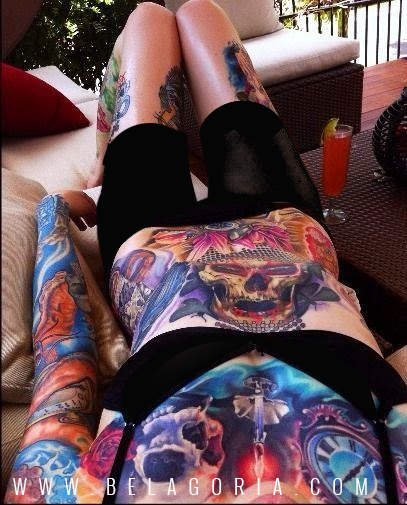 mujer acostada en sofa, lleva tatuajes de calaveras en el abdomen y el pecho,