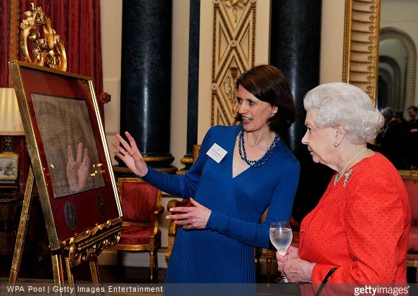 Queen Elizabeth looks on as she is shown a copy of the magna carta by Dr Claire Breay of the British Library during a reception to mark the 800th anniversary of the Magna Carta at at Buckingham Place