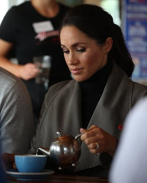 Meghan Markle wore Club Monaco Ellayne trench coat, Stuart Weitzman Veruka suede boots and Outland Denim Harriet Jeans