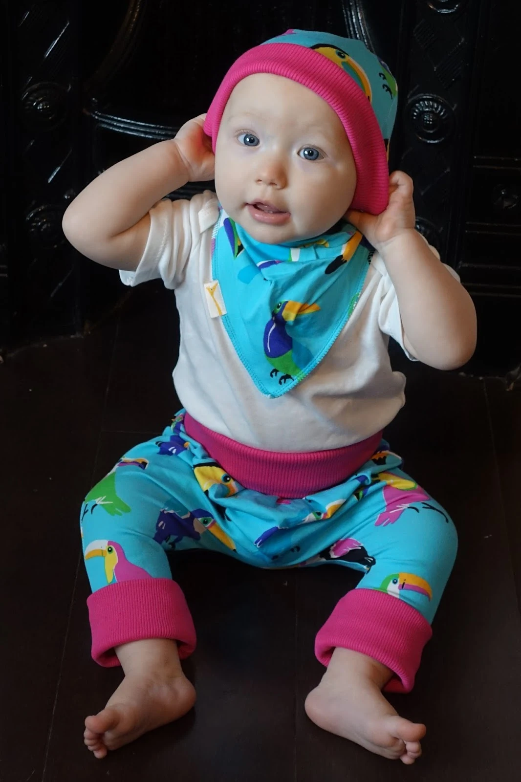 Baby with her hands on her head in Funky Giraffe Clothes