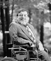 a profile photo of Mr. Ronald Mace -man with a grey beard sitting on a wheelchair