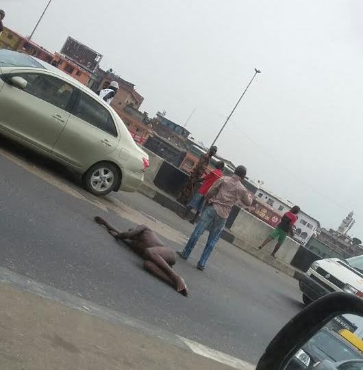 d Photos: Unidentified man strips naked, lies on the road causing traffic in Lagos