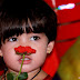 A LITTLE GIRL DREAMING WITH A RED FLOWER
