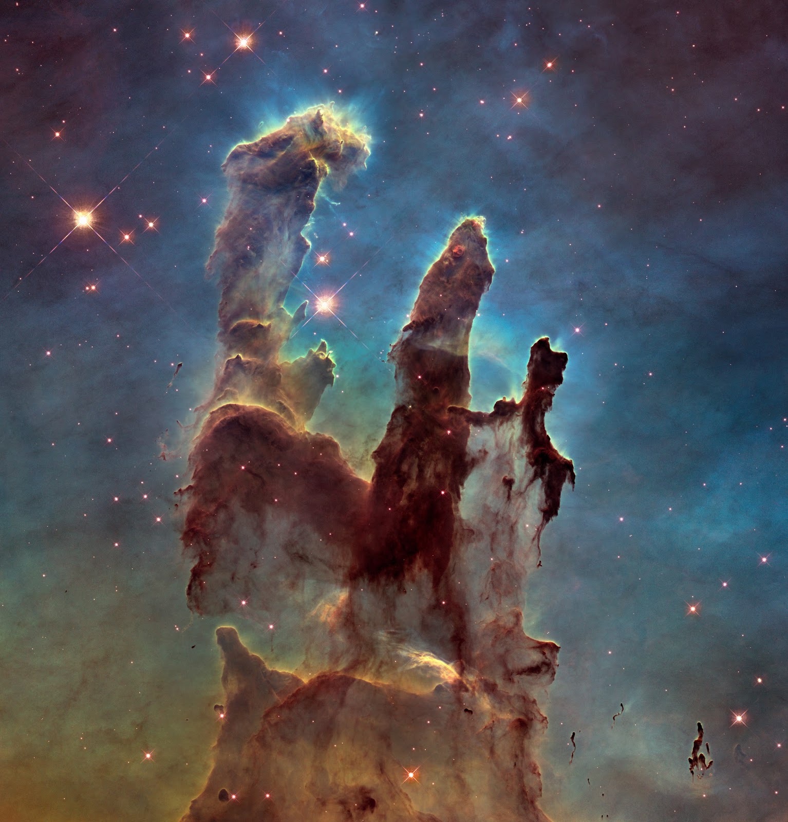New view of the Pillars of Creation New view of the Pillars of Creation   The NASA/ESA Hubble Space Telescope has revisited one of its most iconic and popular images: the Eagle Nebula’s Pillars of Creation. This image shows the pillars as seen in visible light, capturing the multi-coloured glow of gas clouds, wispy tendrils of dark cosmic dust, and the rust-coloured elephants’ trunks of the nebula’s famous pillars.  The dust and gas in the pillars is seared by the intense radiation from young stars and eroded by strong winds from massive nearby stars. With these new images comes better contrast and a clearer view for astronomers to study how the structure of the pillars is changing over time.  Image Credit: NASA, ESA/Hubble and the Hubble Heritage Team Explanation from: http://www.spacetelescope.org/images/heic1501a/