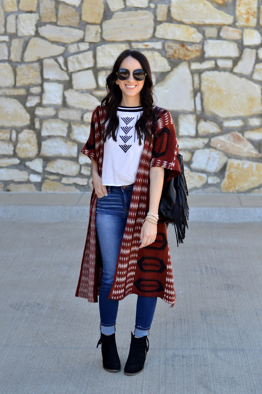 Festival Outfit wearing an aztec crop top and cardigan with a fringe bag 