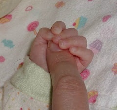 Lily holds Aunt Wendy's finger: 3 mos.