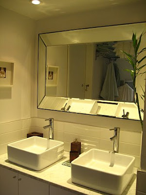 Bathroom in a NYC apartment after remodeling with double sinks and custom beveled mirror
