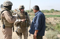 1st Lt. David B. Gilliland, a 24-year-old Civil Affairs team leader with Team 3, 2nd Battalion, 11th Marine Regiment, Regimental Combat Team 1, works with an interpreter to speak with an Iraqi contractor about an irrigation canal being built in Sophia area of Ramadi, Iraq, Oct. 8. Gilliland, originally from Florence, Ky., and the team of Civil Affairs Marines are working with the Government of Iraq to ensure the local farming community has access to several irrigation canals being built.