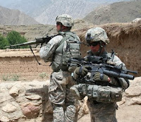 Sgt. Dustin Kaminiski and Staff Sgt. Johnny L. Bates stand guard in a small village in Kunar province Aug. 1.
