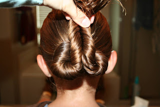 Young girl's hair being styled into "Pretzel-Twist Messy Bun"