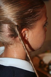 Side view of young girl's hair being styled into "Hair Headband" hairstyle