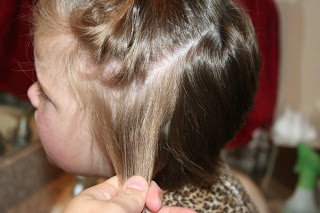 side view of young girl's hair being styled into 3-barrel curl hairstyle on her a-line bob