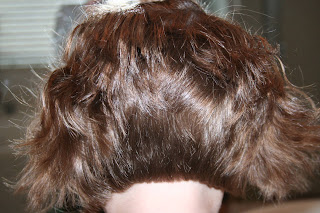 back view of young girl's hair being styled into 3-barrel curl hairstyle on her a-line bob