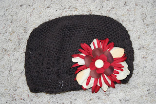 Product photo of chocolate-brown beanie with a red and cream big flower