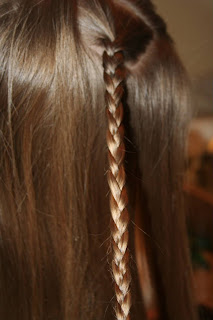 Side view of young girl's hair being styled into "Teen Slide-Up Braid" hairstyle outside