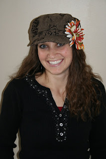 A woman with long hair smiling and wearing a hat