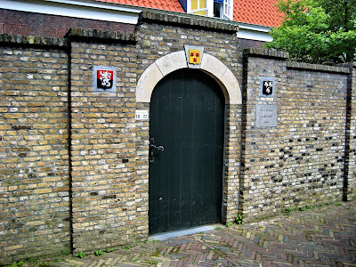 Aan weerszijden van het toegangspoortje bevinden zich twee kleine gevelstenen met de wapenschilden van Van der Goes en D’Oultremont