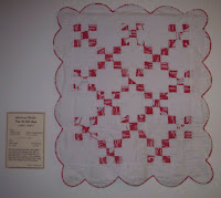 red nine patch quilt with scalloped edges