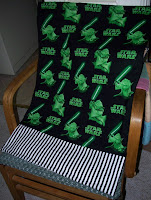 dark green pillowcase with the words Star Wars and the image of Yoda finished with black and white stripes