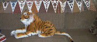 row of triangles on back of couch with big, stuffed tiger under it