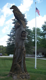 carved tree with an eagle, rabbit, fish, baby eagle and cattails