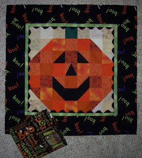 pumpkin with smiling face, narrow lime green border with black rick rack and a 3 inch black border with BOO written in different colors